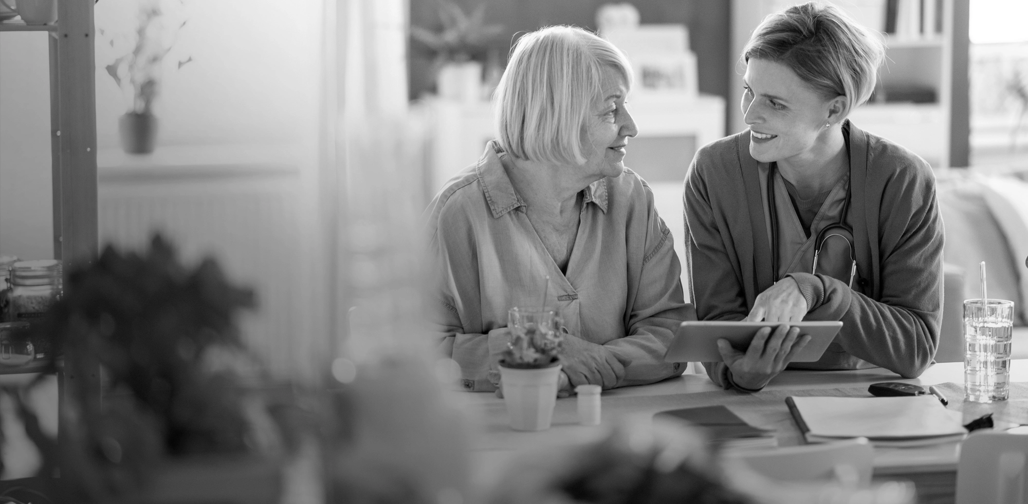Medarbejder i hjemmeplejen forklarer noget til en borger via en tablet