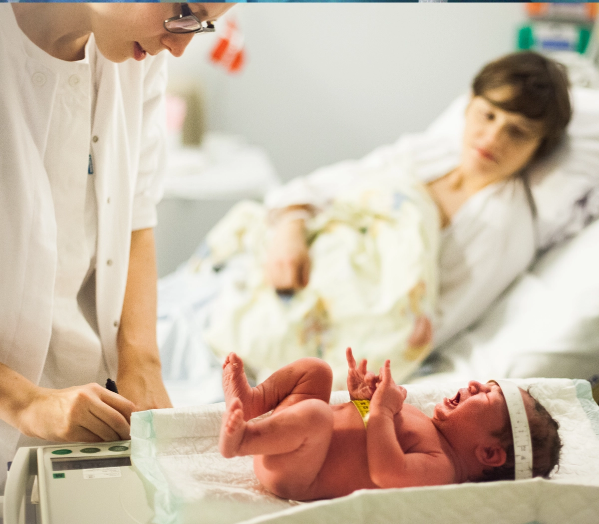 Jordemoder vejer og måler nyfødt baby