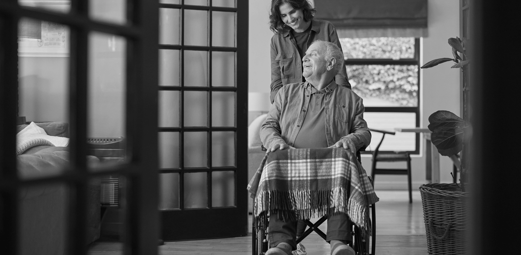 SOSU-assistent kører en ældre borger i kørestol