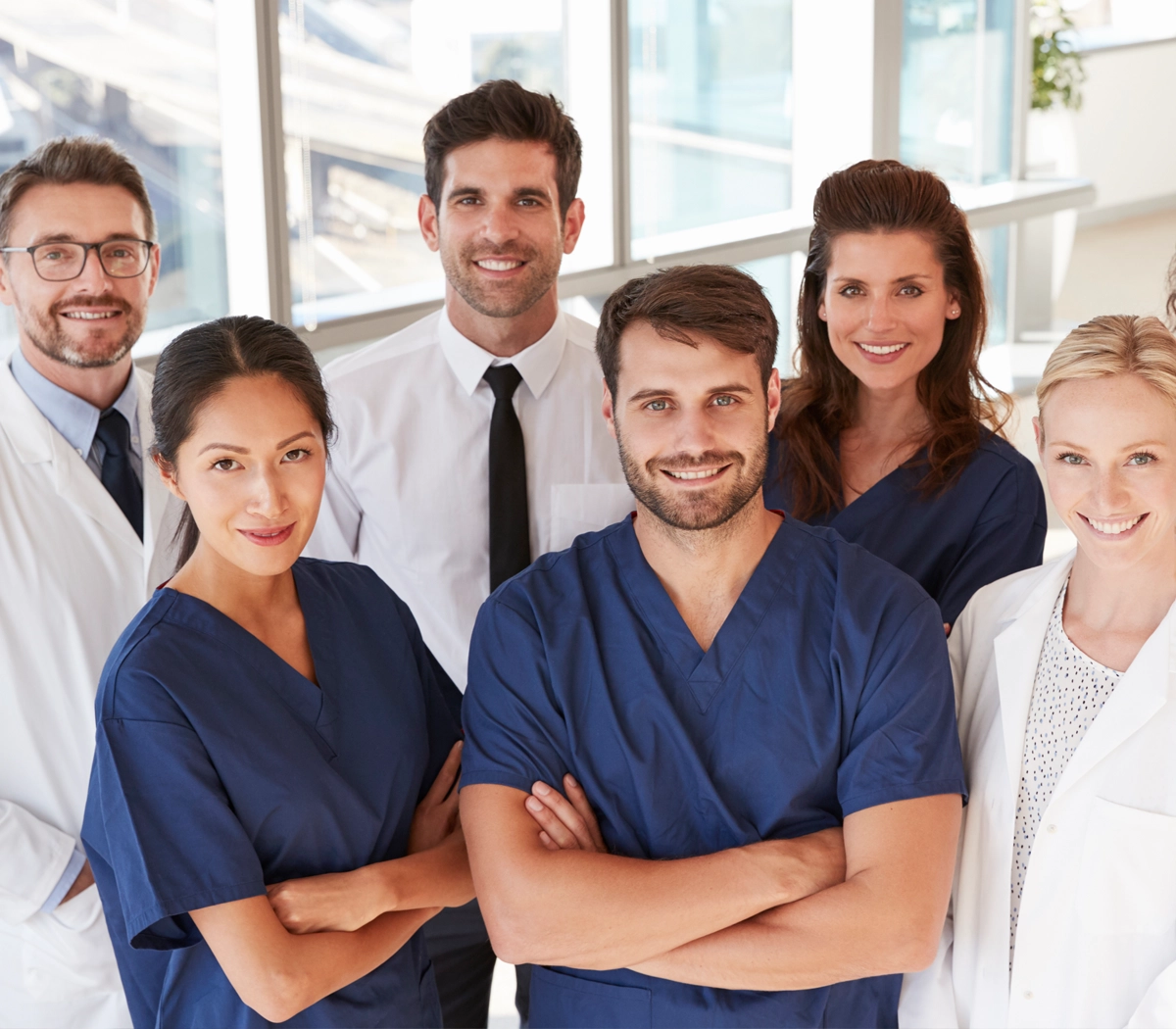 Sygeplejerske og andet sundhedsfagligt personale står sammen og smiler