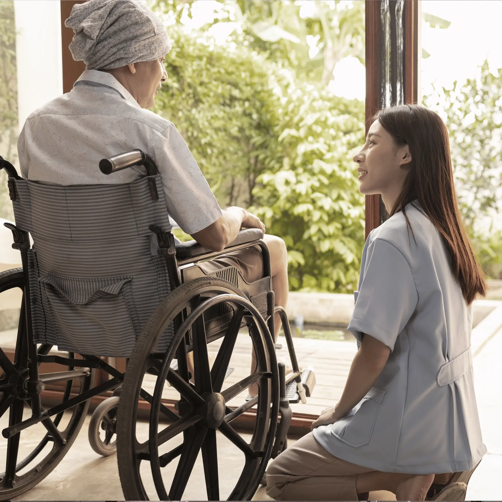 Hjemmehjælper taler med kørestolsbruger